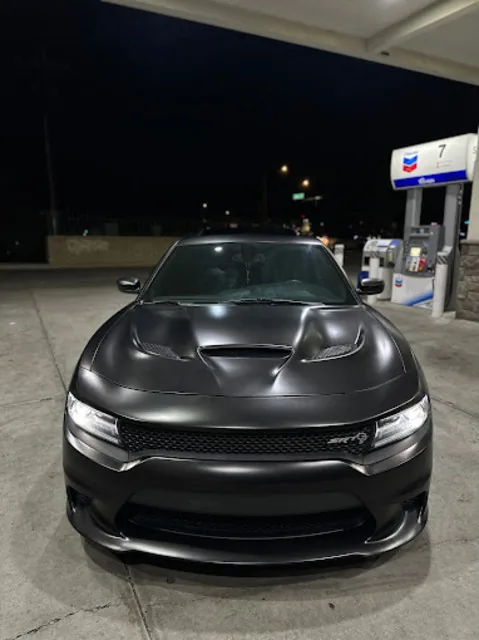 Matte black Dodge Charger SRT viewed head on at night, hood scoops and blacked out grille