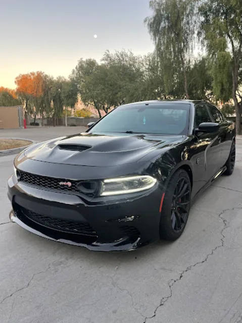 Gloss black Dodge Charger SRT with tinted glass parked on an Arizona street at dusk